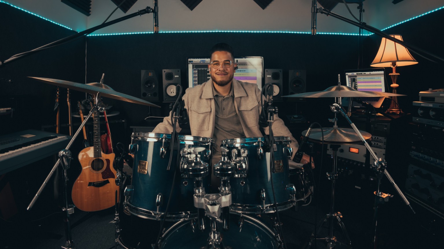 Kevin Michael Chong seated at his mic-equipped drum kit in the studio