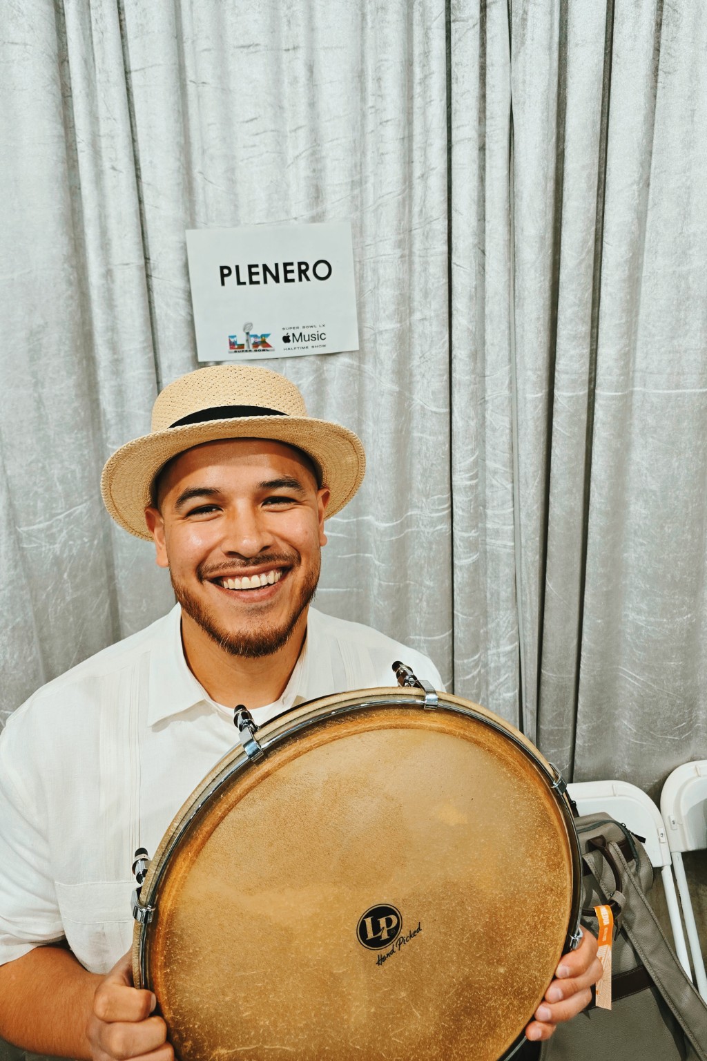 Kevin Michael Chong holding his plena drum backstage at Super Bowl LX